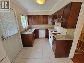 Burnaby apartment for rent - A kitchen with brown cabinets and white appliances.