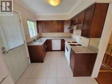 Burnaby apartment for rent - A kitchen with brown cabinets and white appliances.