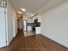 Toronto (West Humber-Clairville) condo for rent - A well-lit, empty kitchen and living room with wooden floors and white walls.