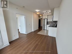 Toronto (West Humber-Clairville) condo for rent - A spacious room with wooden flooring and white walls.