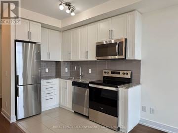 Toronto (West Humber-Clairville) condo for rent - A kitchen with white cabinets and stainless steel appliances.