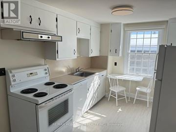 Augusta apartment for rent - A white kitchen with a stove, sink, and cabinets.