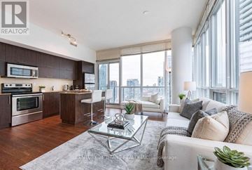Toronto (Waterfront Communities) condo for rent - A modern kitchen with dark wood cabinets and stainless steel appliances.