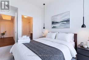 Toronto (Waterfront Communities) condo for rent - A bedroom with a large bed and a painting on the wall.