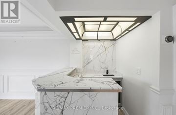 Vaughan (East Woodbridge) apartment for rent - A white marble countertop with a modern kitchen island and a skylight above it.