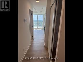 Brantford condo for rent - A hallway with a view of the ocean through a glass door.