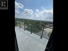 Brantford condo for rent - A balcony with a view of a highway and trees.