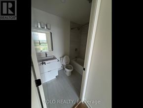 Brantford condo for rent - A bathroom with a toilet, sink and mirror.