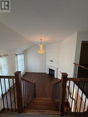 Kitchener apartment for rent - A chandelier hangs in a white room with a wood staircase.