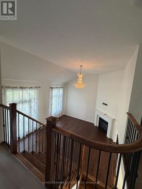 Kitchener apartment for rent - A well-lit living room with a fireplace and a staircase.