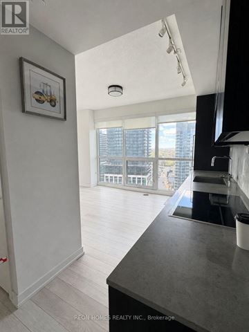 Toronto (Bayview Village) condo for rent - A kitchen with a black counter top and white walls.