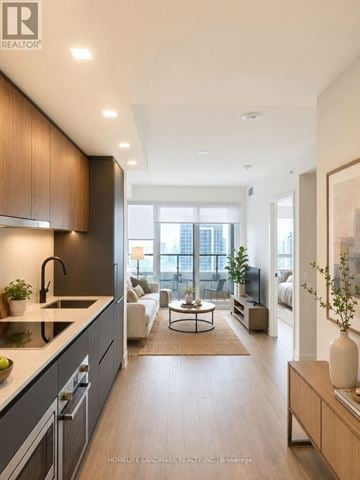Toronto (North St. James Town) condo for rent - A modern kitchen with dark wood cabinets and a white countertop.