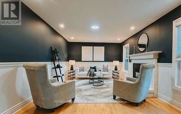 Caledon apartment for rent - A living room with two grey chairs and a fireplace.