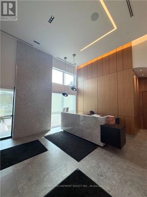 Oakville (Go Glenorchy) condo for rent - A reception area with a white reception desk and a brown wall.