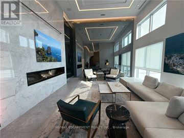 Oakville (Go Glenorchy) condo for rent - A living room with a fireplace and a painting on the wall.