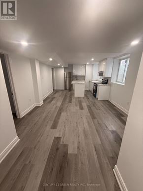 Milton (Cb Cobban) apartment for rent - A spacious room with wooden flooring and white walls.