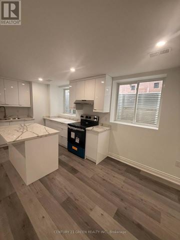 Milton (Cb Cobban) apartment for rent - A kitchen with white cabinets and a wooden floor.