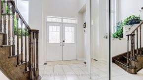 Brampton (Northwest Brampton) apartment for rent - A hallway with a white door and a staircase with a wooden handrail.