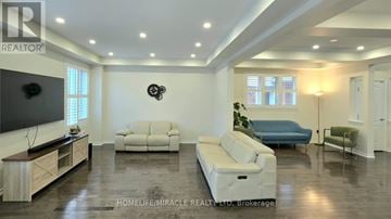 Brampton (Northwest Brampton) apartment for rent - A living room with a white couch and a television on the left side.