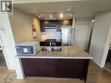 Richmond apartment for rent - A kitchen with a granite countertop and a microwave on it.