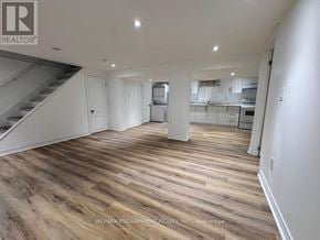 Burlington (Lasalle) apartment for rent - A spacious room with wooden flooring and a staircase on the left side.