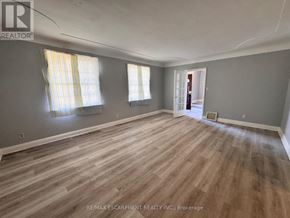 Burlington (Lasalle) apartment for rent - A room with wooden flooring and two windows with curtains.
