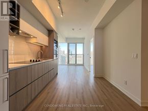 Toronto (Moss Park) condo for rent - A spacious kitchen with wooden floors and a large window.