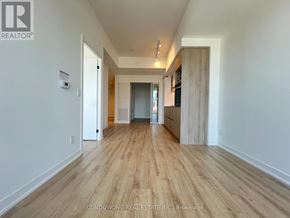 Toronto (Moss Park) condo for rent - A long, narrow hallway with wood flooring and white walls.