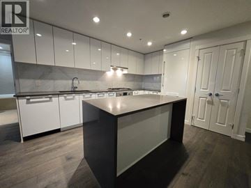 Vancouver apartment for rent - A modern kitchen with white cabinets and a central island.