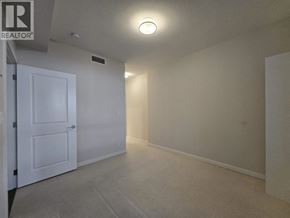 Vancouver apartment for rent - A white door is on the left side of a room with a carpet floor and white walls.