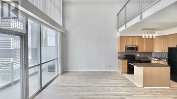 Mississauga (City Centre) condo for rent - A modern kitchen with wooden cabinets and a large island.