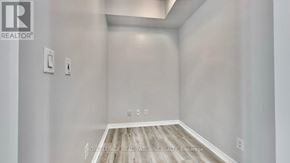 Mississauga (City Centre) condo for rent - A white room with a wooden floor and two switches on the wall.