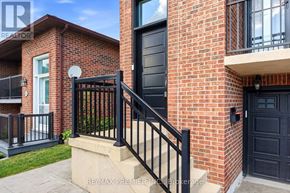 Vaughan (East Woodbridge) apartment for rent - A red brick house with a black gate and steps leading to the front door.