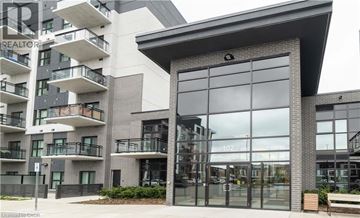Oakville condo for rent - A modern building with a glass entrance and balconies on the left side.