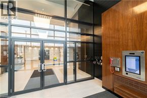 Oakville condo for rent - A modern office lobby with a glass wall and a wooden panelled wall.