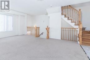 Mississauga (Churchill Meadows) townhouse for rent - A spacious room with a staircase and a carpeted floor.