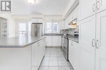 Mississauga (Churchill Meadows) townhouse for rent - A white kitchen with a granite counter top and stainless steel appliances.