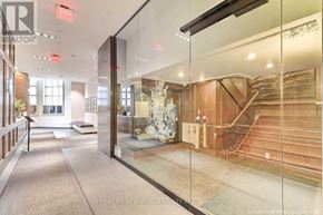Toronto (Kensington-Chinatown) condo for rent - A hallway with a glass wall and a staircase.