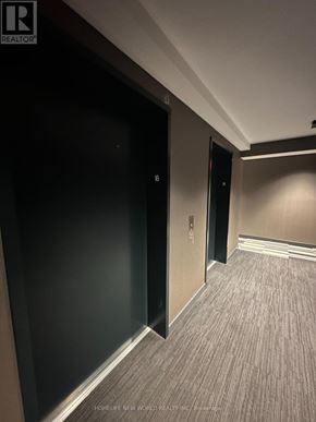 Toronto (Kensington-Chinatown) condo for rent - A hallway with a black door and carpeting.