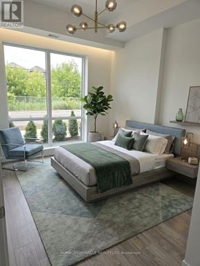 Oshawa (Windfields) condo for rent - A bedroom with a large bed and a view of the outside.