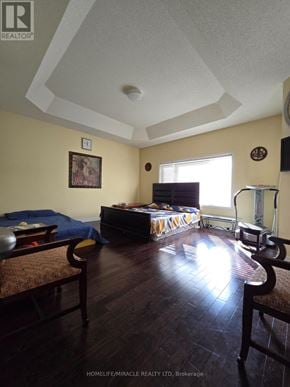 Brampton (Northwest Brampton) apartment for rent - A bedroom with a bed, a chair, and a painting on the wall.