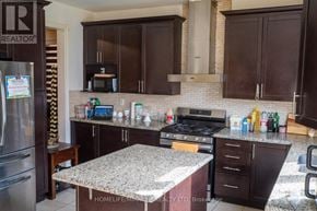 Brampton (Northwest Brampton) apartment for rent - A kitchen with dark brown cabinets and a granite countertop.