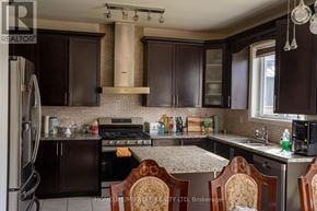 Brampton (Northwest Brampton) apartment for rent - A kitchen with dark brown cabinets and a marble countertop.