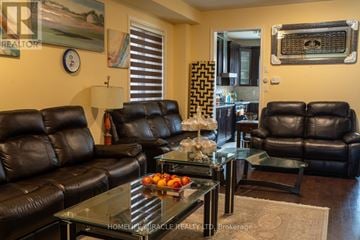 Brampton (Northwest Brampton) apartment for rent - A living room with black leather couches and a glass coffee table.