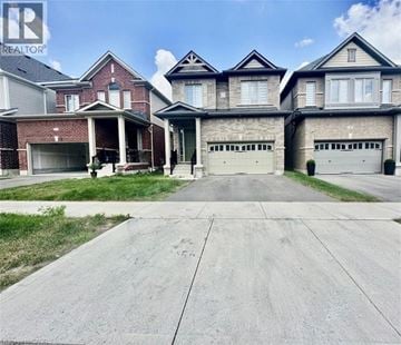 Kitchener apartment for rent - A large, well-maintained house with a driveway in front.