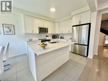 Kitchener apartment for rent - A kitchen with white cabinets and a white island.