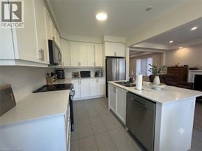Kitchener apartment for rent - A kitchen with white cabinets and a black refrigerator.