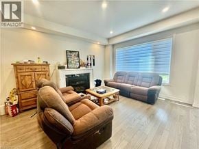 Kitchener apartment for rent - A living room with a brown couch, a wooden cabinet, and a fireplace.