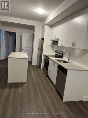 Oakville (Jm Joshua Meadows) condo for rent - A kitchen with white cabinets and a wooden floor.
