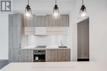 Toronto (Mount Pleasant West) condo for rent - A modern kitchen with wooden cabinets and a white countertop.